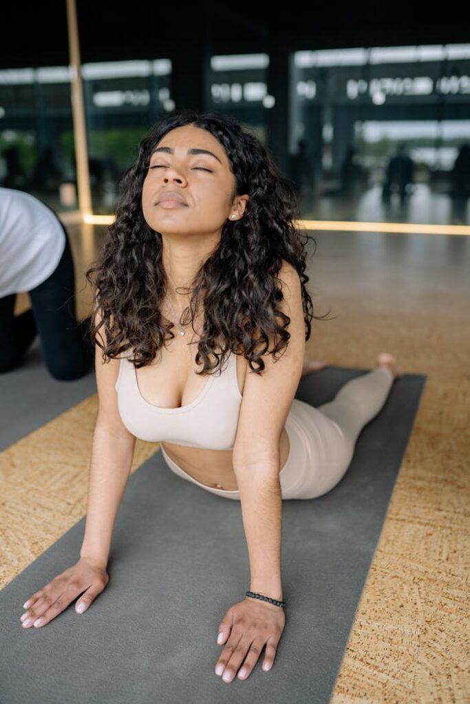 Pilates A young woman practicing yoga in a bright studio, focusing on stretching and relaxation.
